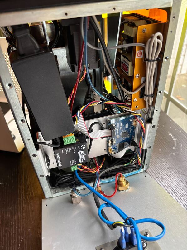 3D printer opened up for repair, showing the mainboard and wiring