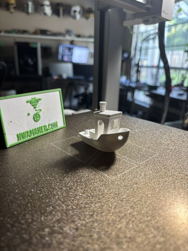 Test print: a clean Benchy next to the NWAMAKER logo